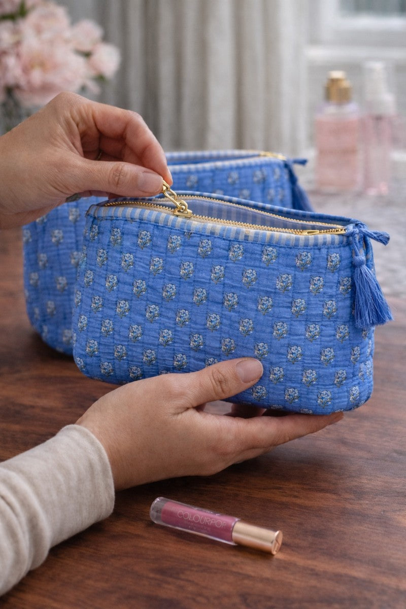 Handblock blue cosmetic pouch with small floral print and striped lining, lifestyle bathroom setup