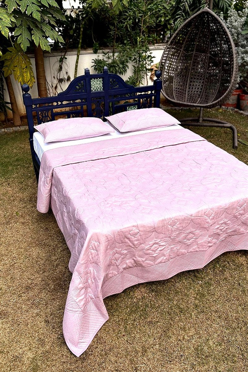 Soft pink quilted bedding set with textured stitch pattern, luxury cotton quilt displayed in natural daylight”