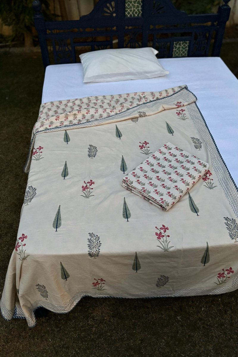 Ivory cotton single bed dohar with pink flower bootis and green tree motifs in hand block print