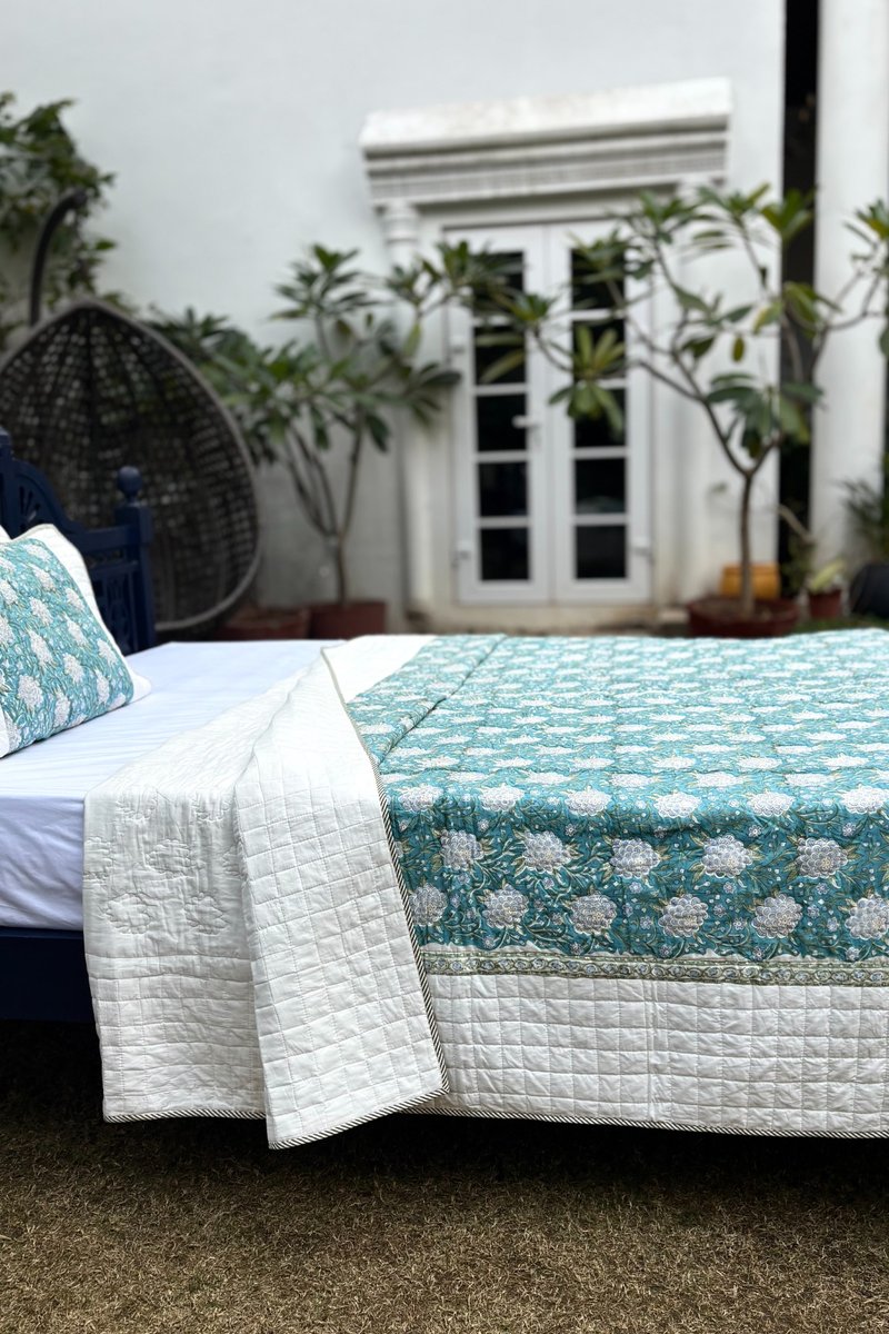 Teal floral hand quilted cotton quilt with detailed stitching and soft ivory edging
