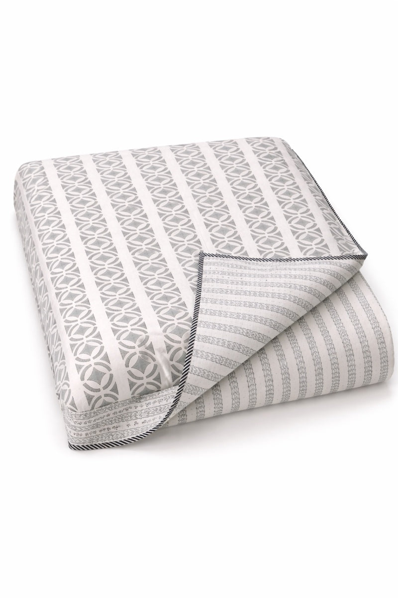 Folded gray and white patterned cotton dohar on a white background