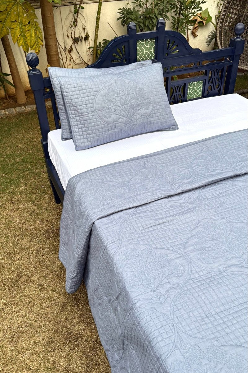 Close-up of grey cotton quilt highlighting intricate quilting pattern, fine craftsmanship, and soft breathable texture