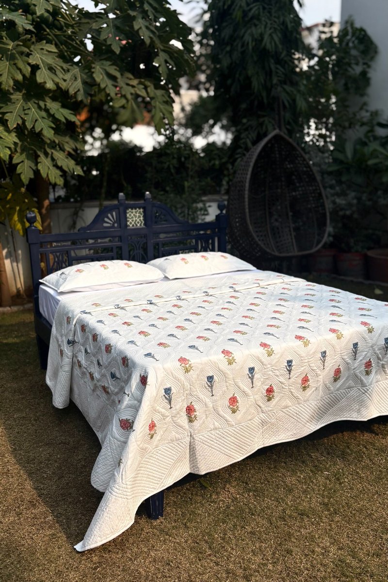 Cream hand quilted cotton quilt with Gulnaar floral print, featuring pink and blue block motifs and detailed stitching