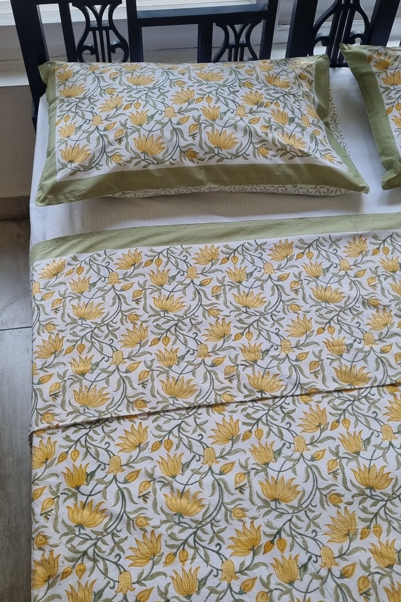 Close up of yellow lotus floral block print cotton bedsheet with matching pillow covers