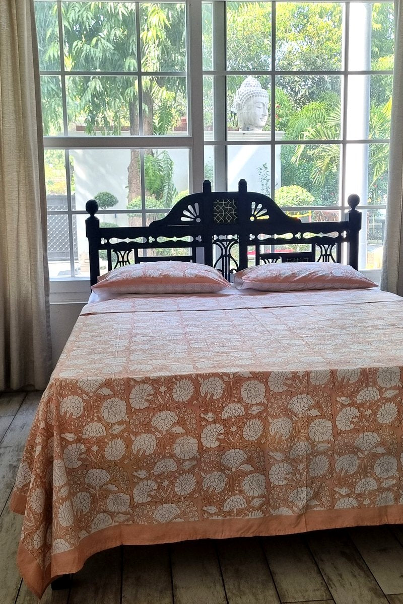 Close up of peach and white botanical block print bedsheet with coordinated pillow covers