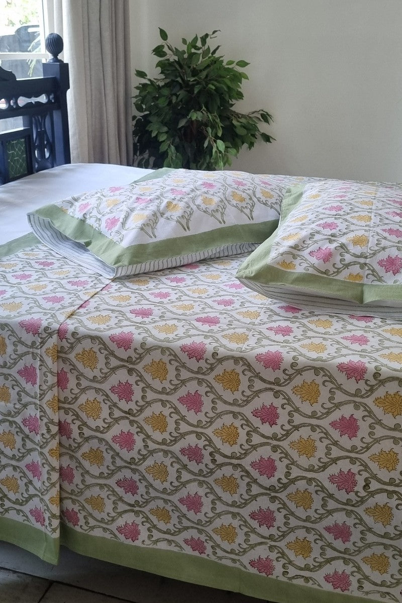 Floral vine block print bedsheet styled on wooden bed with coordinated pillow covers