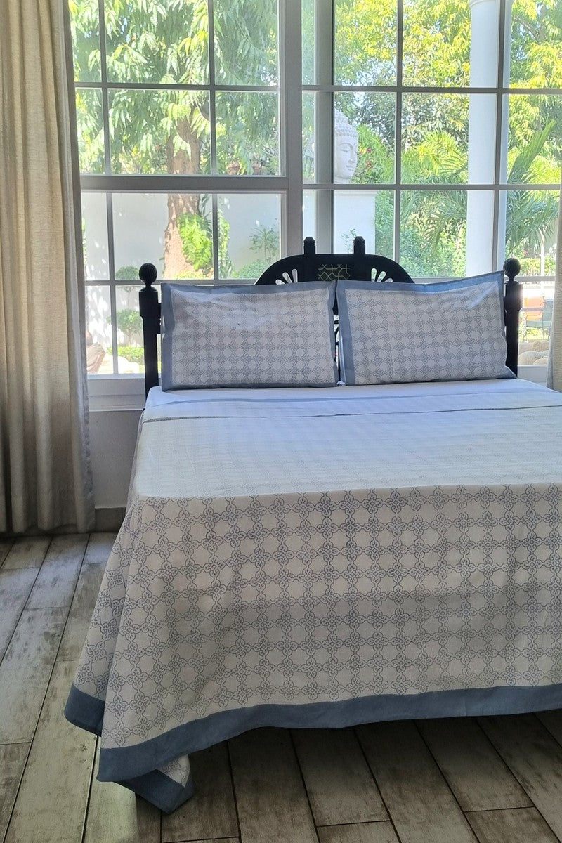 Close up of grey and white geometric block print bedsheet with coordinated pillow covers