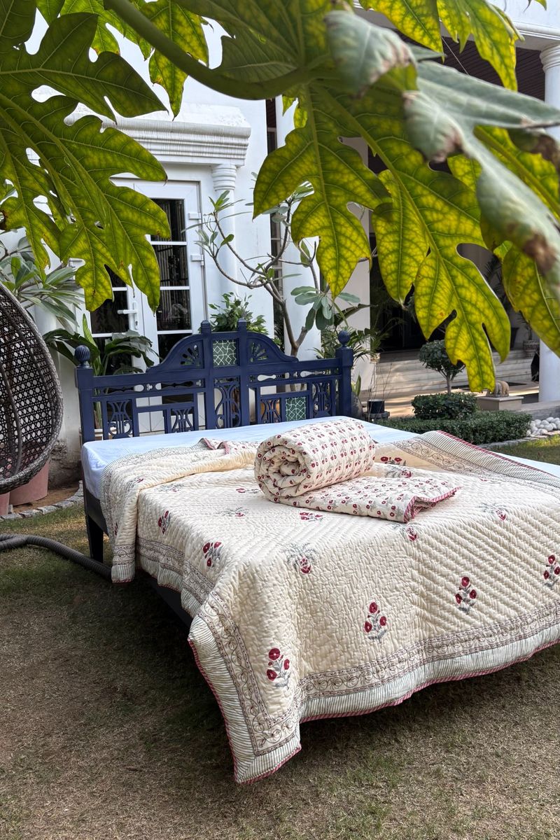 Ivory floral block print quilt set with red buti motifs and striped border, handcrafted cotton bedding for bedroom