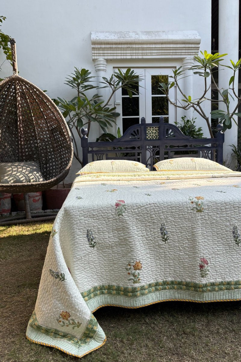 Soft quilted cotton bedspread with pastel floral buta print and decorative green border, handcrafted Indian bedding