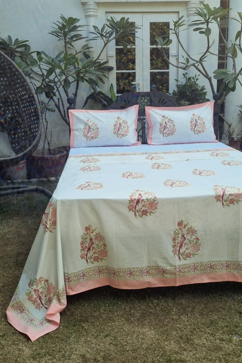 Pink bird floral hand block print cotton bedsheet with border, outdoor garden setting, king size bedding set