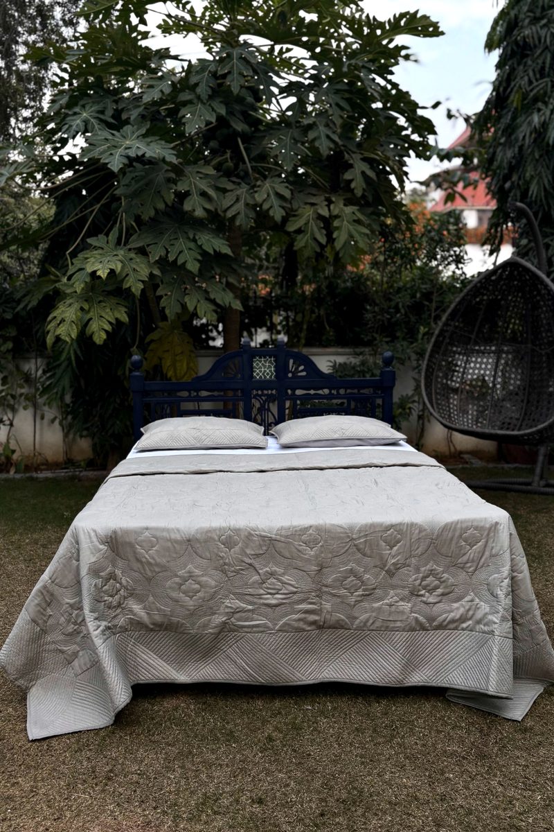 Soft Oatmeal quilted bedspread set with tonal hand quilting on cotton, styled on a garden bed