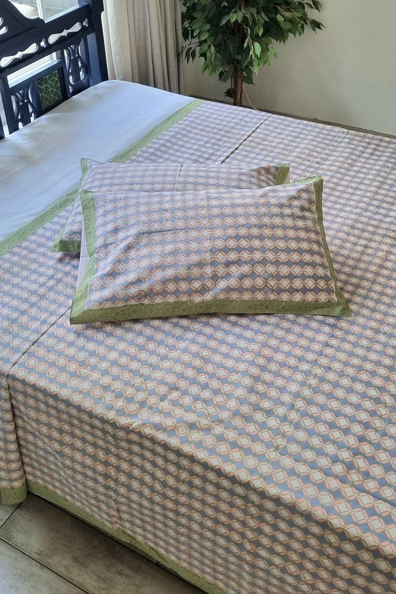 Parko block print cotton bedsheet set with geometric pattern and green border, king size bedding styled indoors