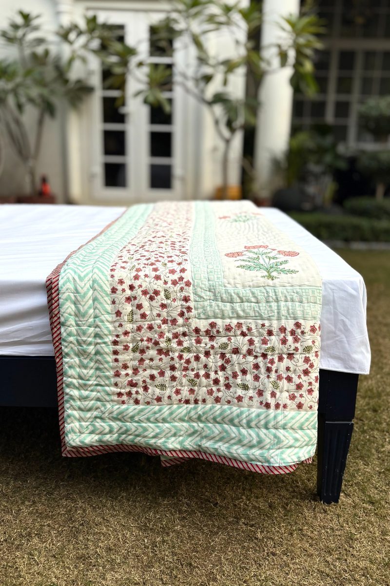 Detail view of hand block printed quilt border with floral and chevron patterns, soft cotton reversible bedding
