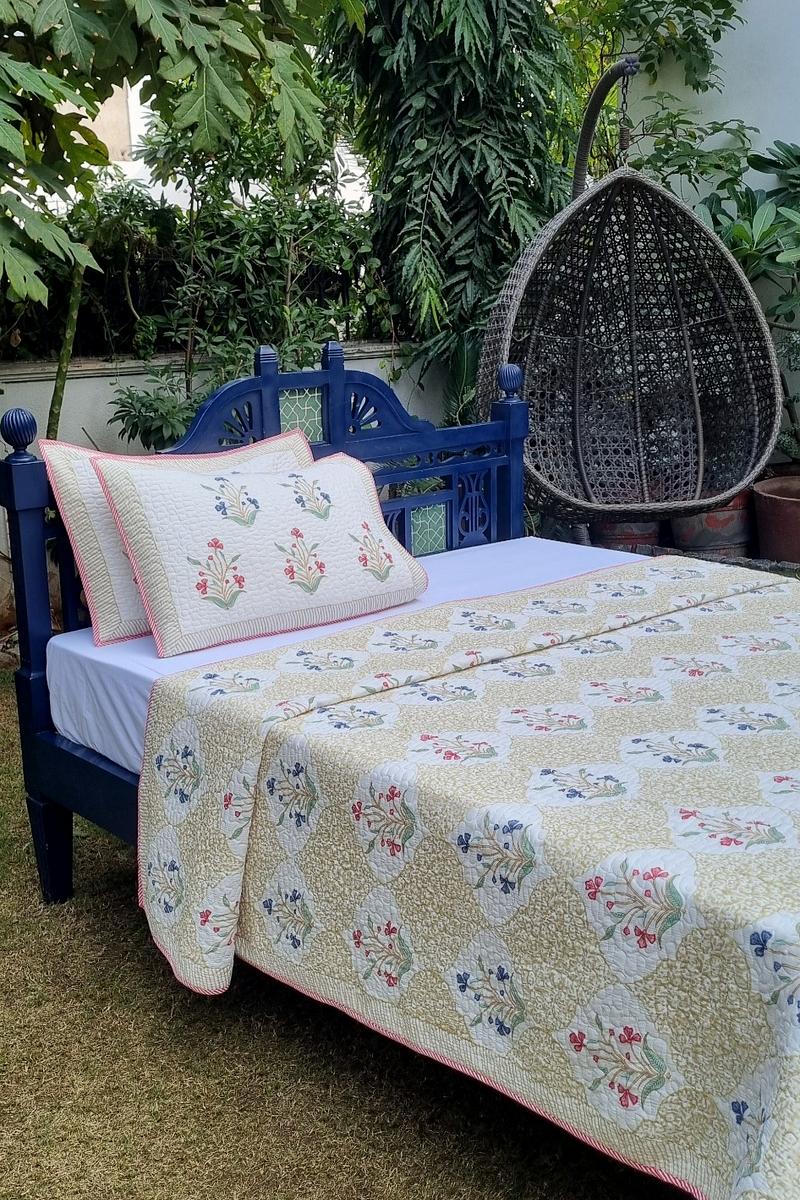Reversible handblock cotton bedcover in soft ivory and pastel floral motif with pink piping detail