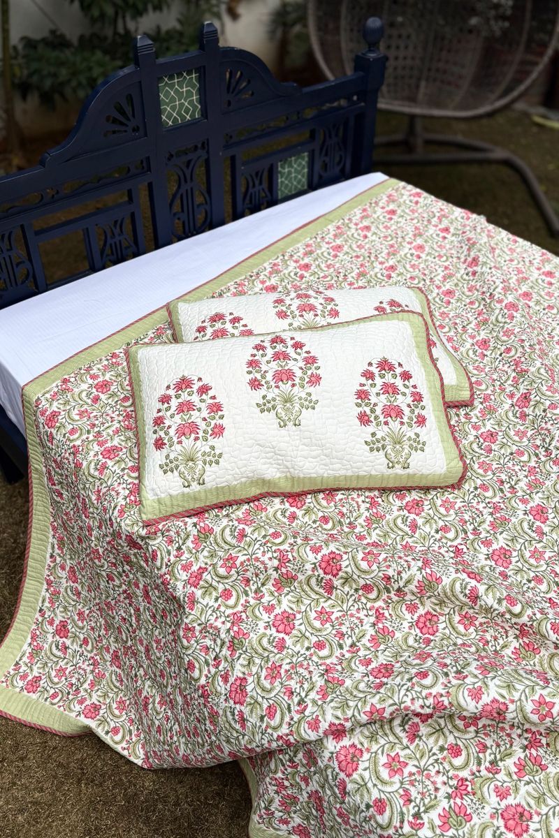 Reversible cotton quilted bedcover with pink floral print front and green striped backing, handcrafted Indian bedding