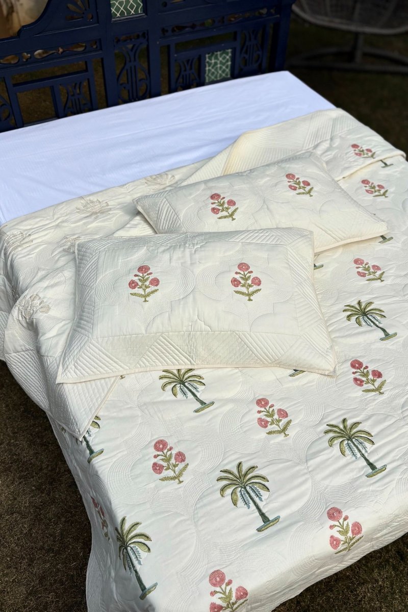 Palm print ivory quilt set styled on bed, handcrafted cotton quilt for modern bedrooms