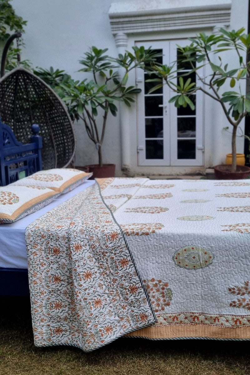 Reversible Mughal inspired floral bedcover with peach border and fine quilting texture