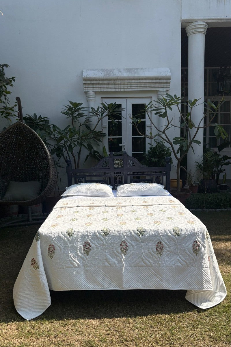 Close up of ivory quilted pillow cover with traditional floral buti design