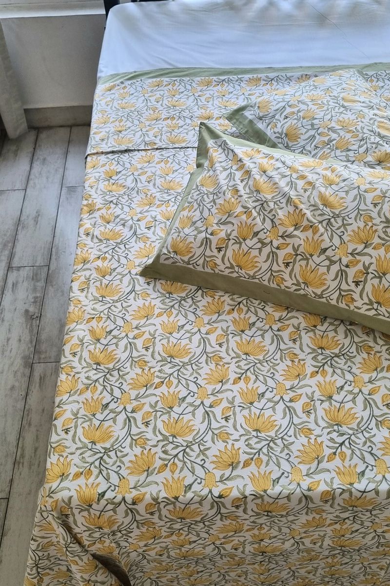 Hand block printed cotton bedsheet in mustard yellow floral pattern with sage green edging