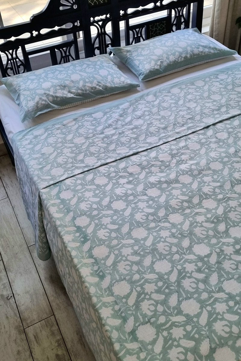 Soft sage green block print bedsheet with white botanical design and solid border