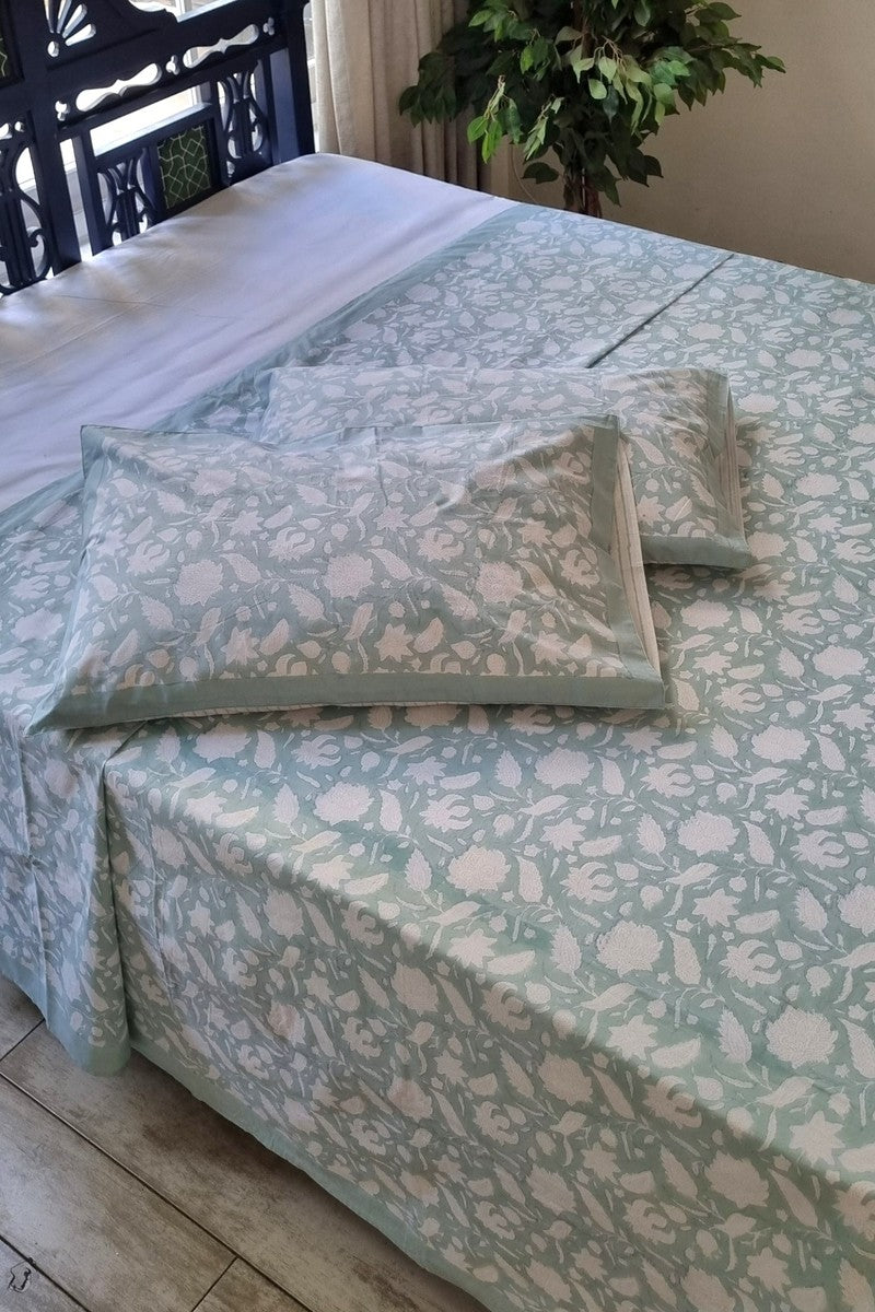Mint green hand block print cotton bedsheet set with white floral pattern and matching pillow covers