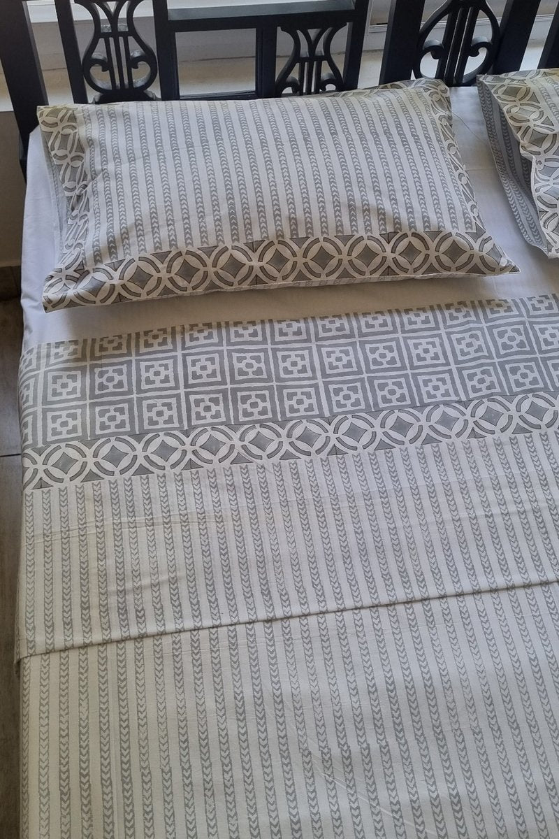 Close up of grey striped hand block printed cotton bedsheet with decorative geometric border