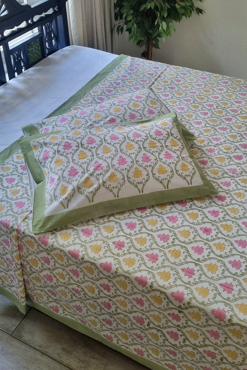 Pink and mustard floral hand block print cotton bedsheet set with sage green border and matching pillow covers