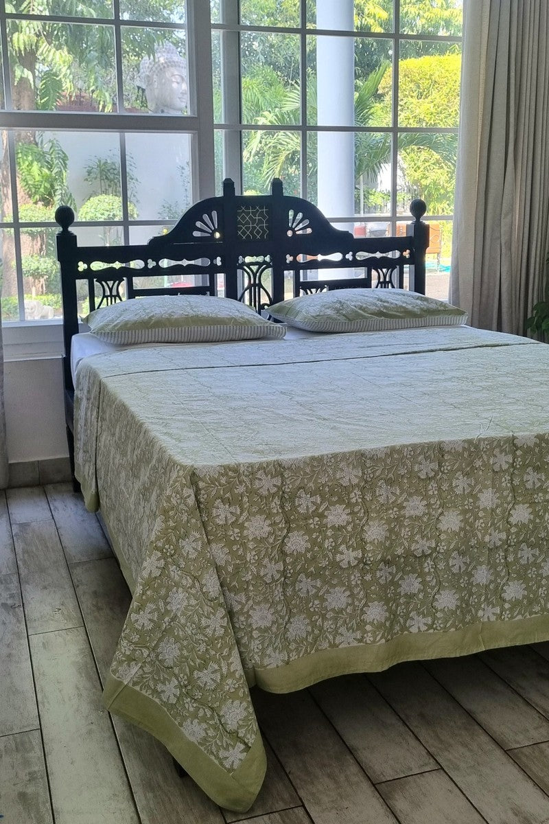 Green and white floral hand block printed cotton bedsheet set with wooden headboard and garden view background