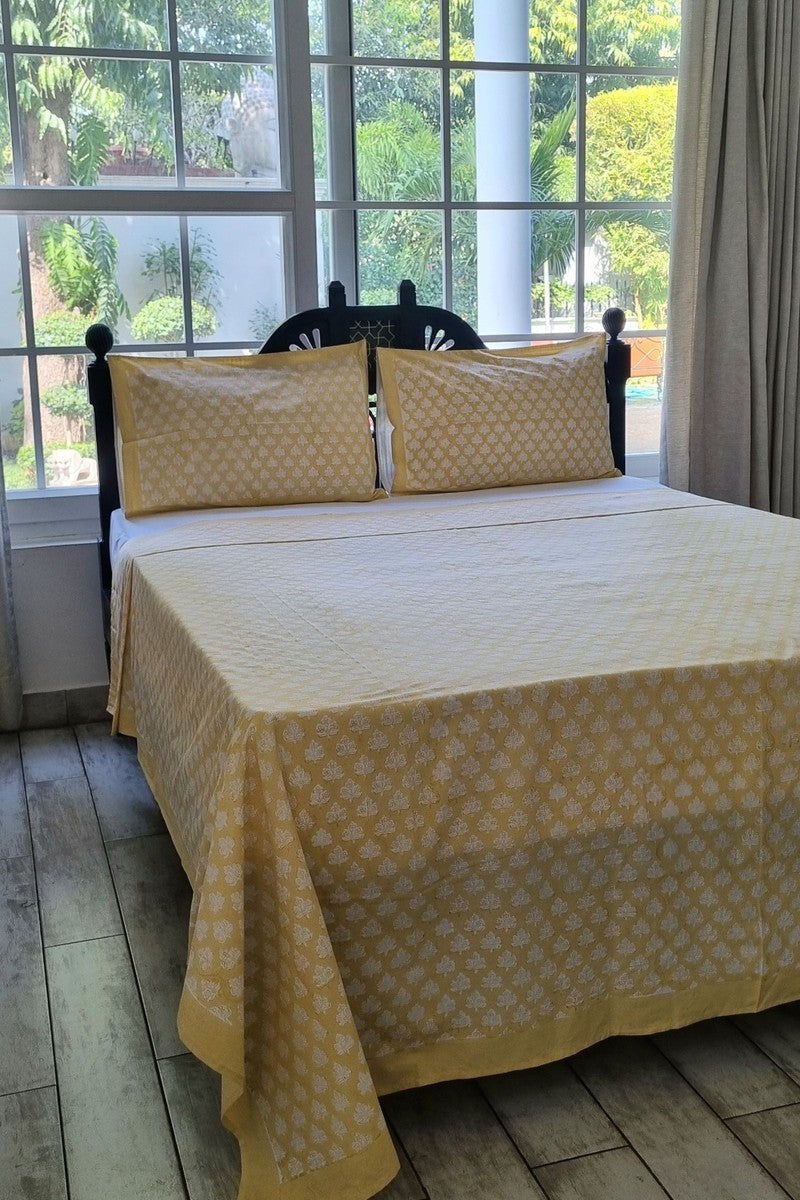 Elegant yellow Jaipuri hand block print bedsheet with traditional white floral design and coordinated pillow covers
