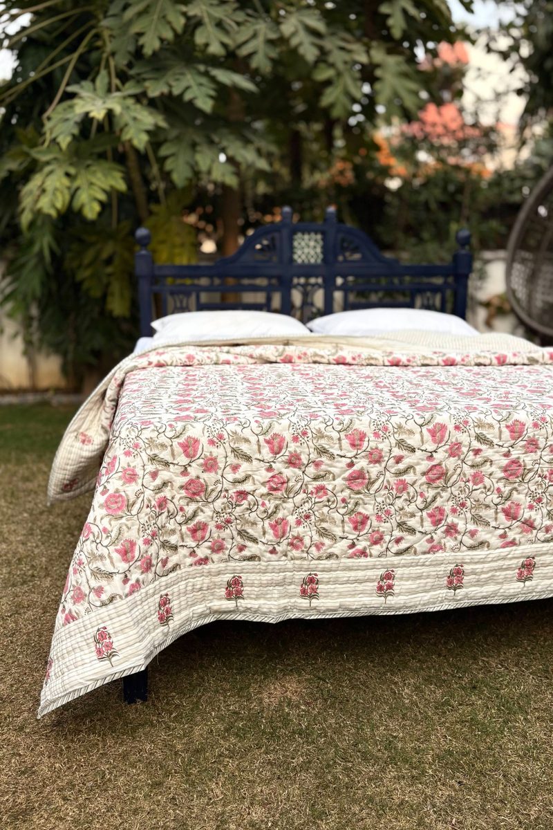 Close-up of Jaal Bagh hand block printed quilt showing intricate pink floral jaal design on soft cotton fabric