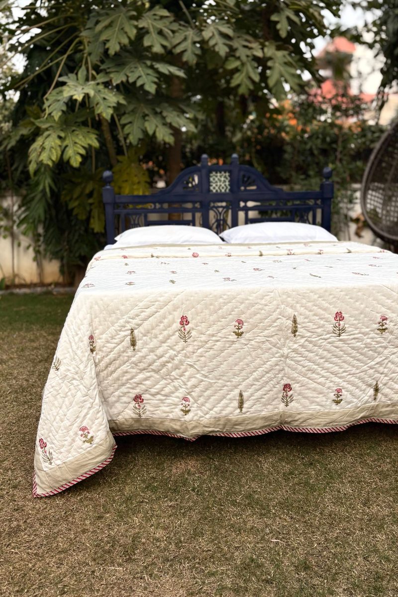 Artisan-made cream block print cotton quilt styled outdoors, lightweight handcrafted Indian bedding