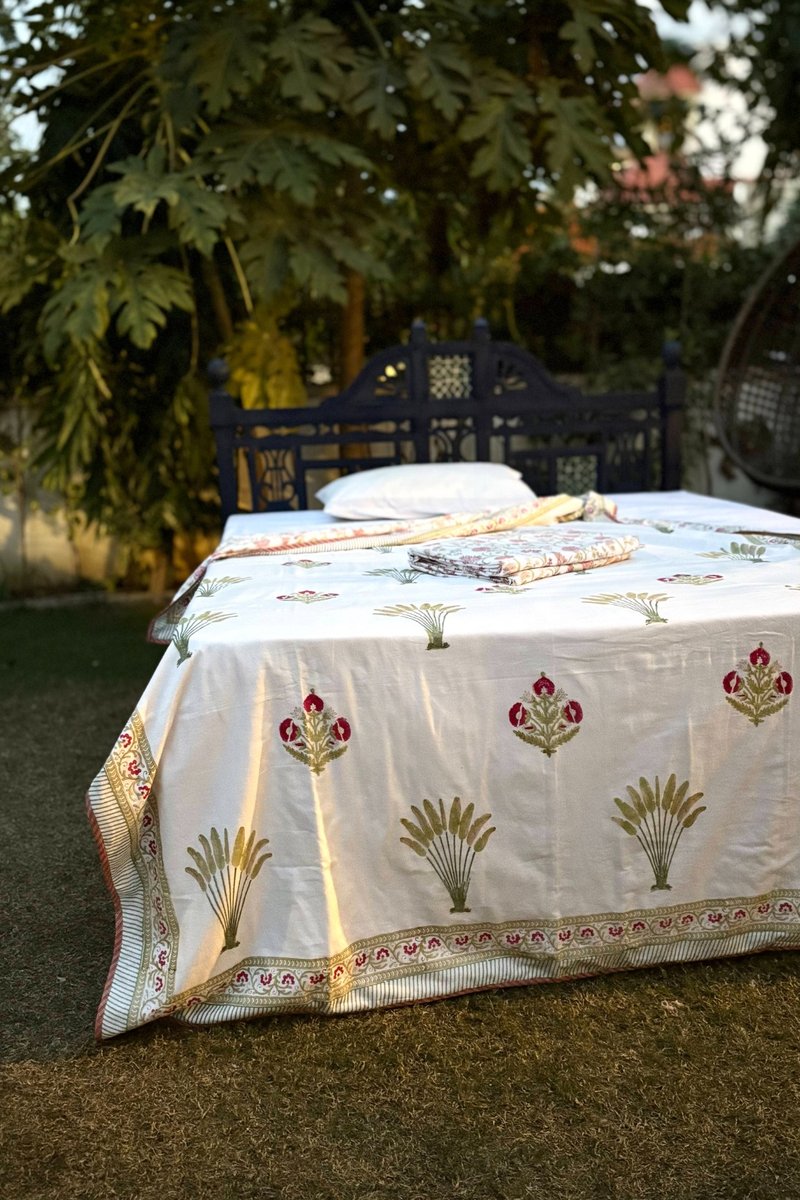 hand block print cotton dohar with rose floral motifs styled on outdoor garden bed