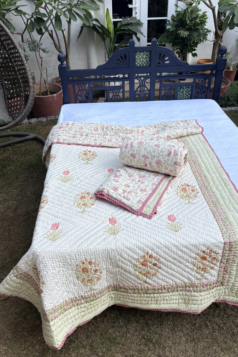 Cream quilt with intricate floral bouquet print and striped green border in soft cotton finish