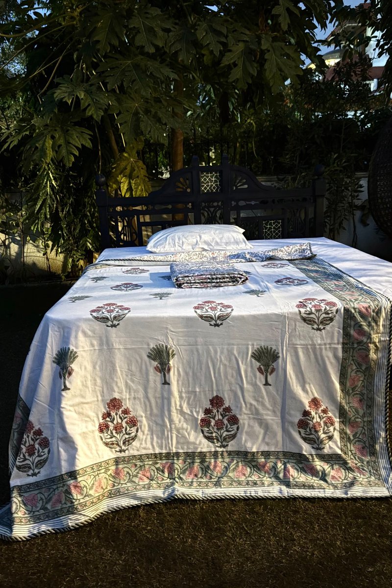 White hand block printed cotton dohar set with pink floral motifs and green palm trees, decorative floral border.
