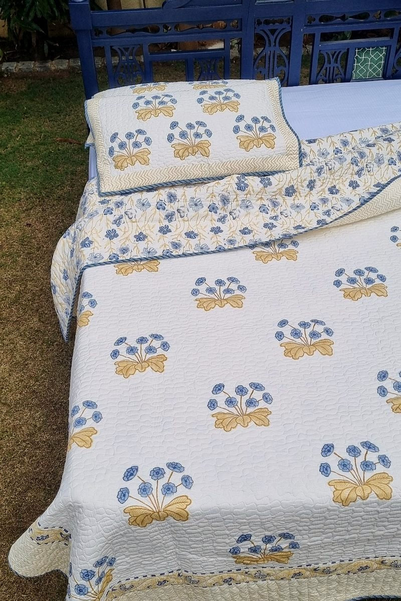 Premium reversible bedcover set in white with blue flowers and golden accents