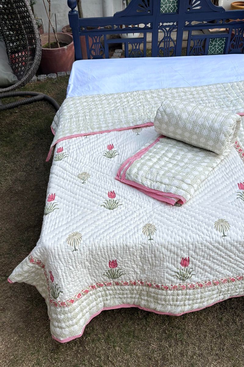 Premium handcrafted Quilt featuring pink floral block print on soft ivory base
