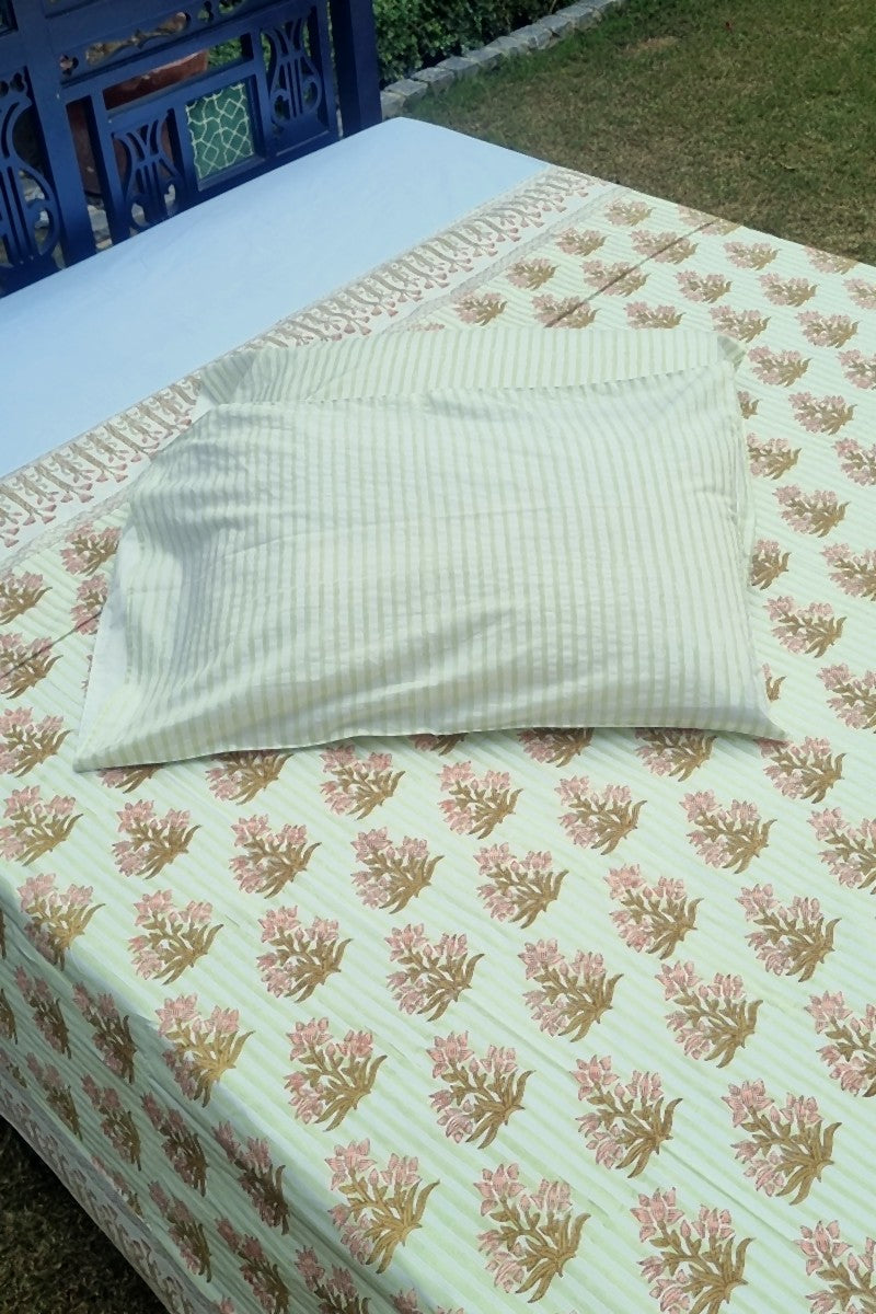 Close up of green striped cotton bedsheet with brown floral buti print and detailed border design