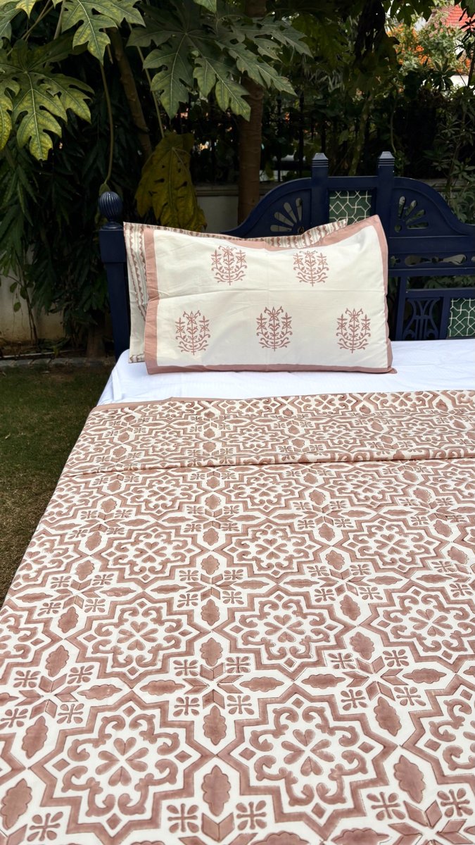 Close up of blush pink jaal handblock print on white cotton bedsheet showing detailed geometric floral pattern