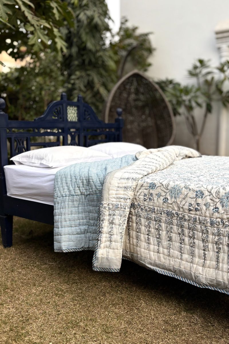 Luxury blue hand block printed quilt styled outdoors, breathable cotton bedding with traditional Indian floral motifs