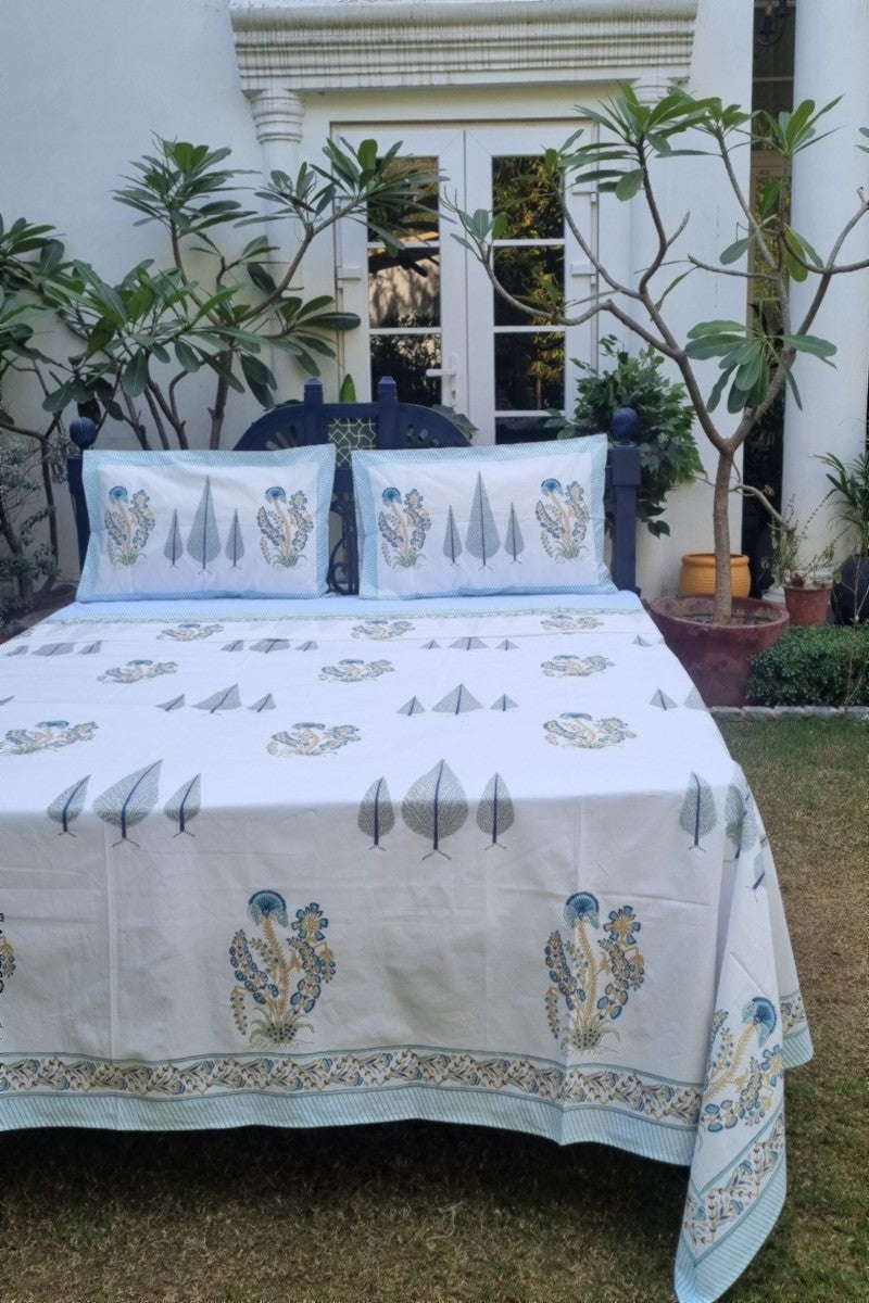 Blue and sage green Indian block printed bedsheet with matching pillow covers and botanical motifs on white base