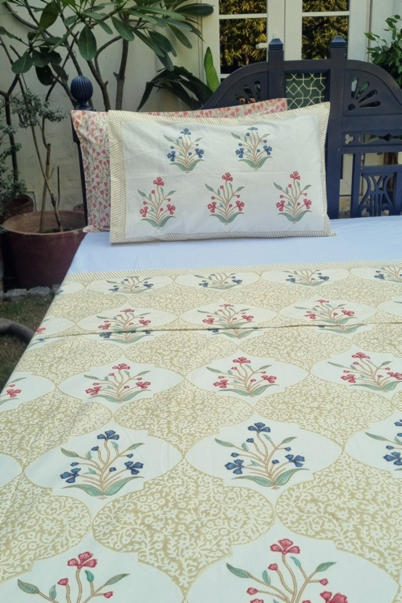 Cotton pillow covers with matching red and blue floral block print on beige geometric patterned bedsheet