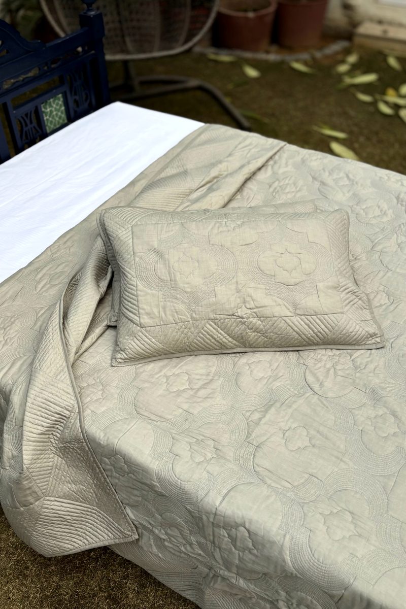 Neutral soft oatmeal cotton quilt with detailed hand quilting and matching pillow covers