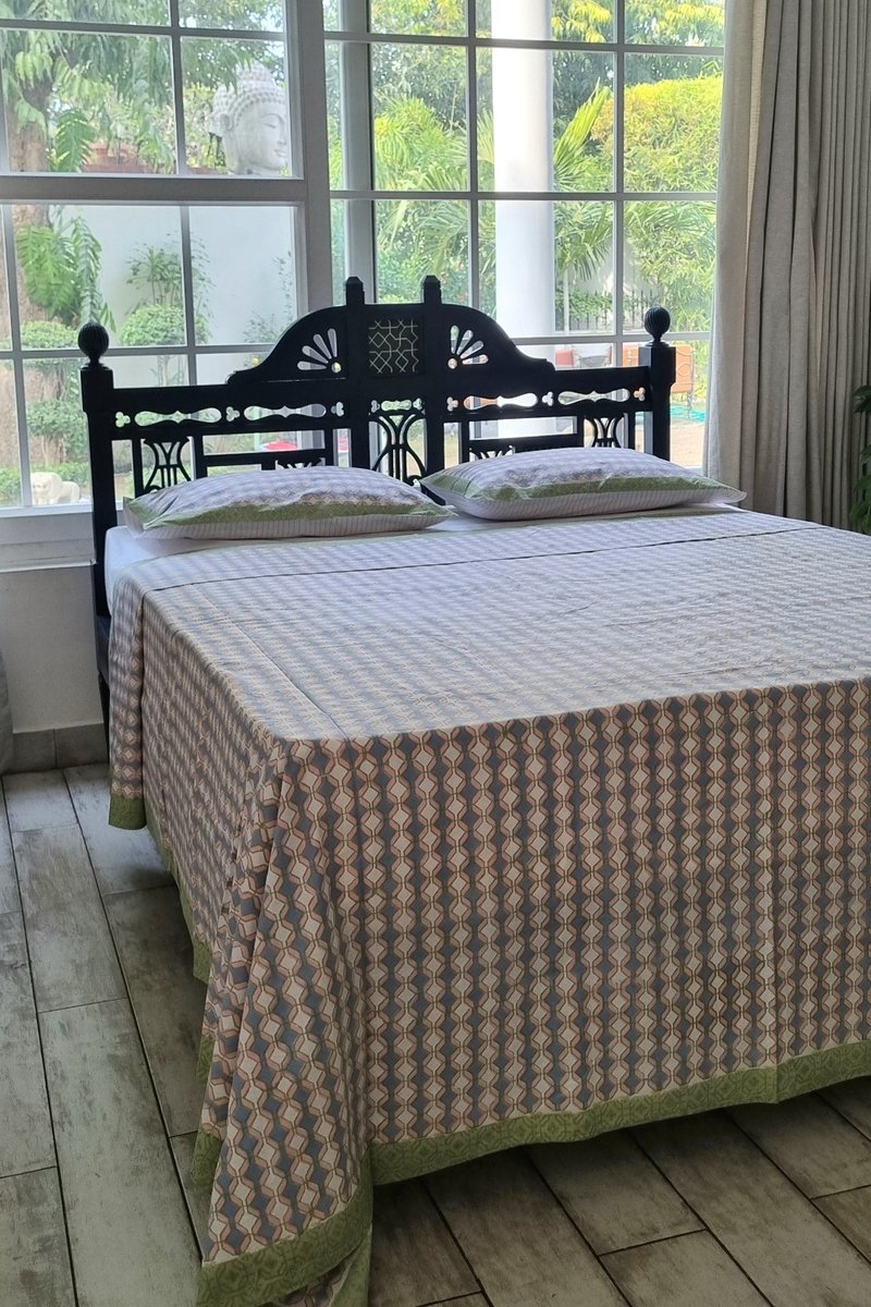 Geometric hand block print cotton bedsheet in pastel blue and peach with green border detail
