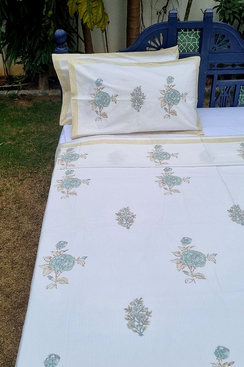 Floral handblock printed cotton bedsheet in aqua and ivory with matching pillowcases and subtle border design