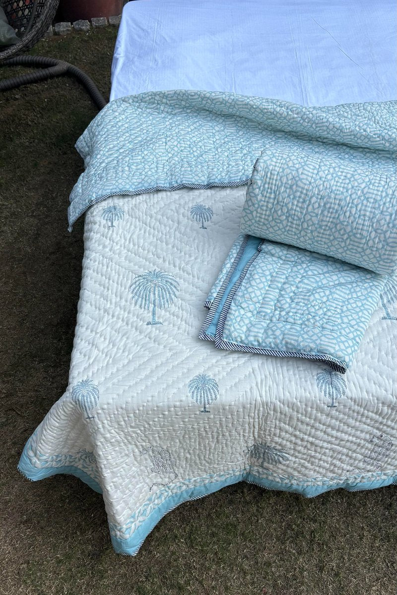 Soft ivory quilt with aqua palm tree print and contrast border, handcrafted cotton bedding