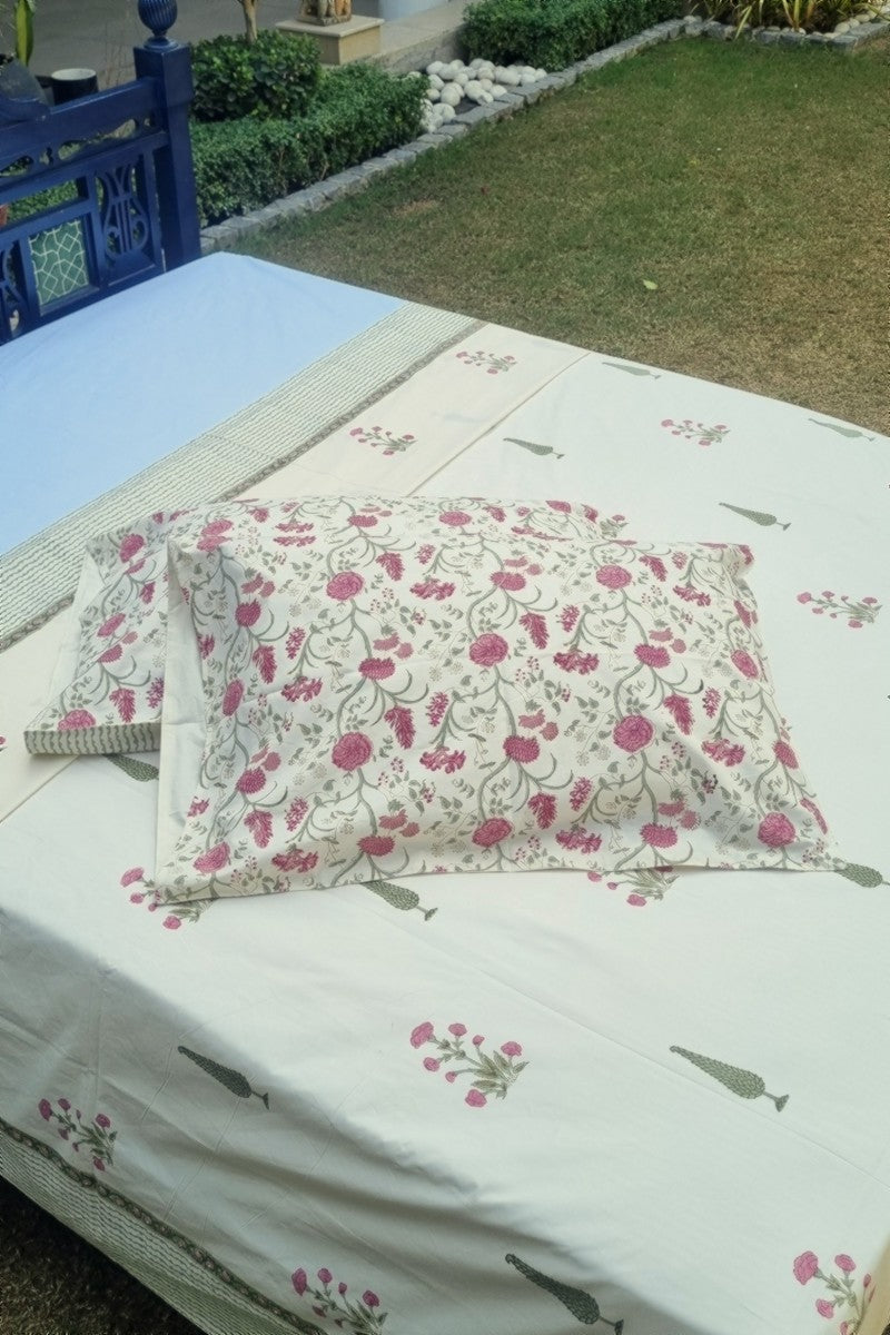 Cotton pillow covers with pink floral vine block print paired with ivory bedsheet in traditional Indian design