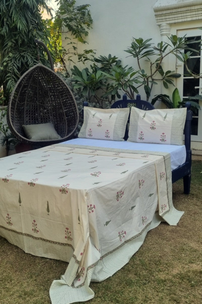 Premium white cotton bedsheet featuring hand block pink botanical print with coordinated border and pillow covers