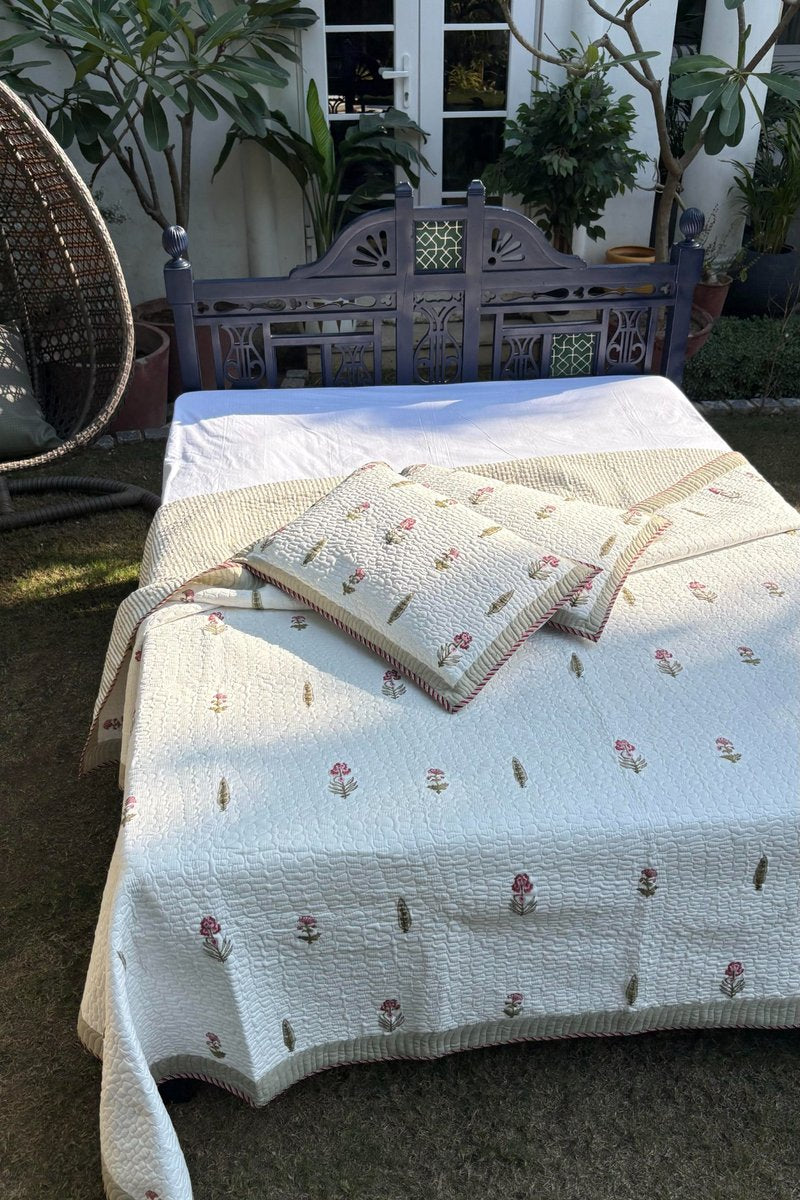 Soft quilted cotton bedspread in ivory with delicate pink flower print and striped border detail