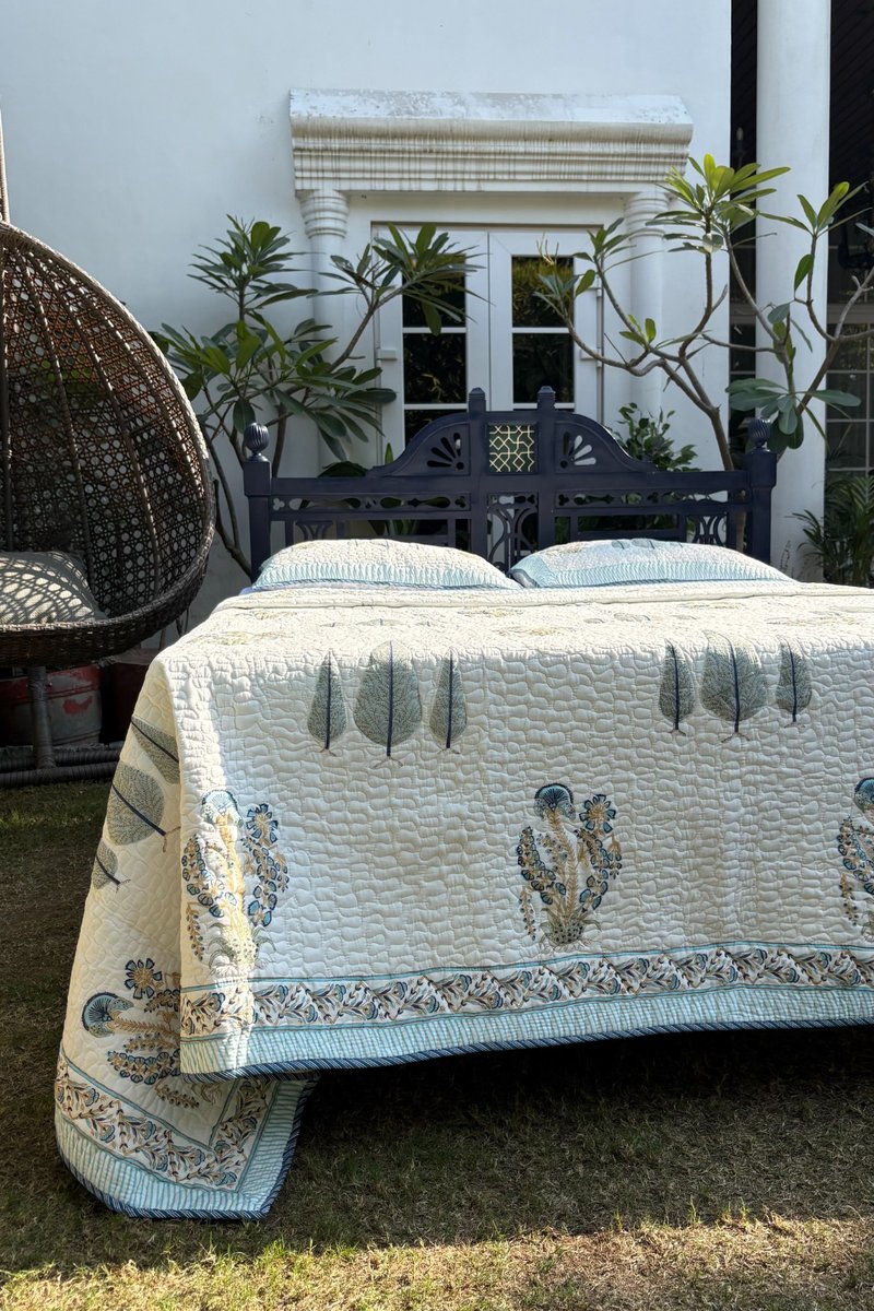 Ivory hand block printed cotton quilt with Mughal floral buta and blue leaf border design
