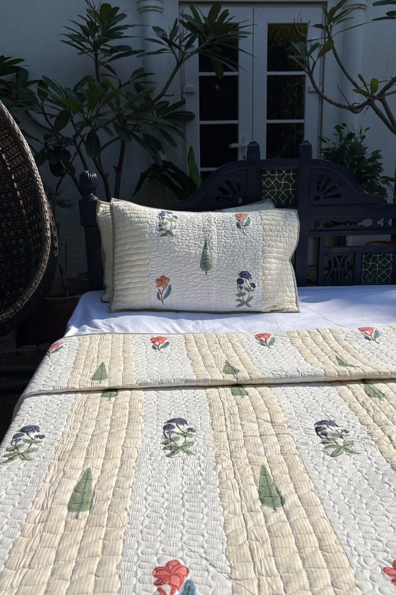 Reversible hand block print cotton quilt showing floral jaal backing and ivory striped front design